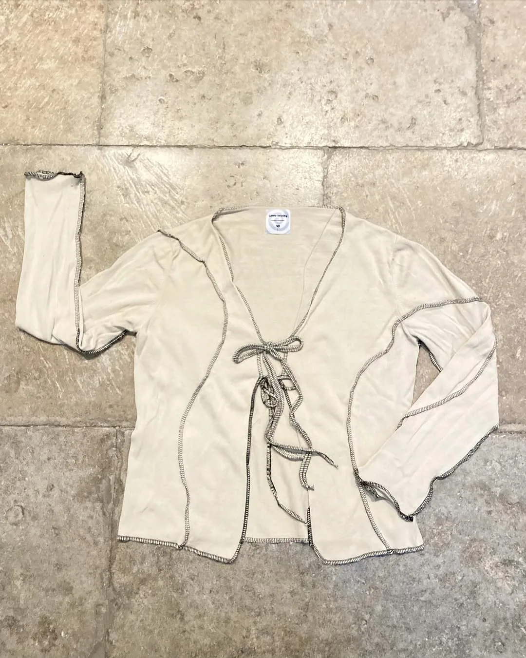 Gilet cache-cœur beige à motifs surjet noir