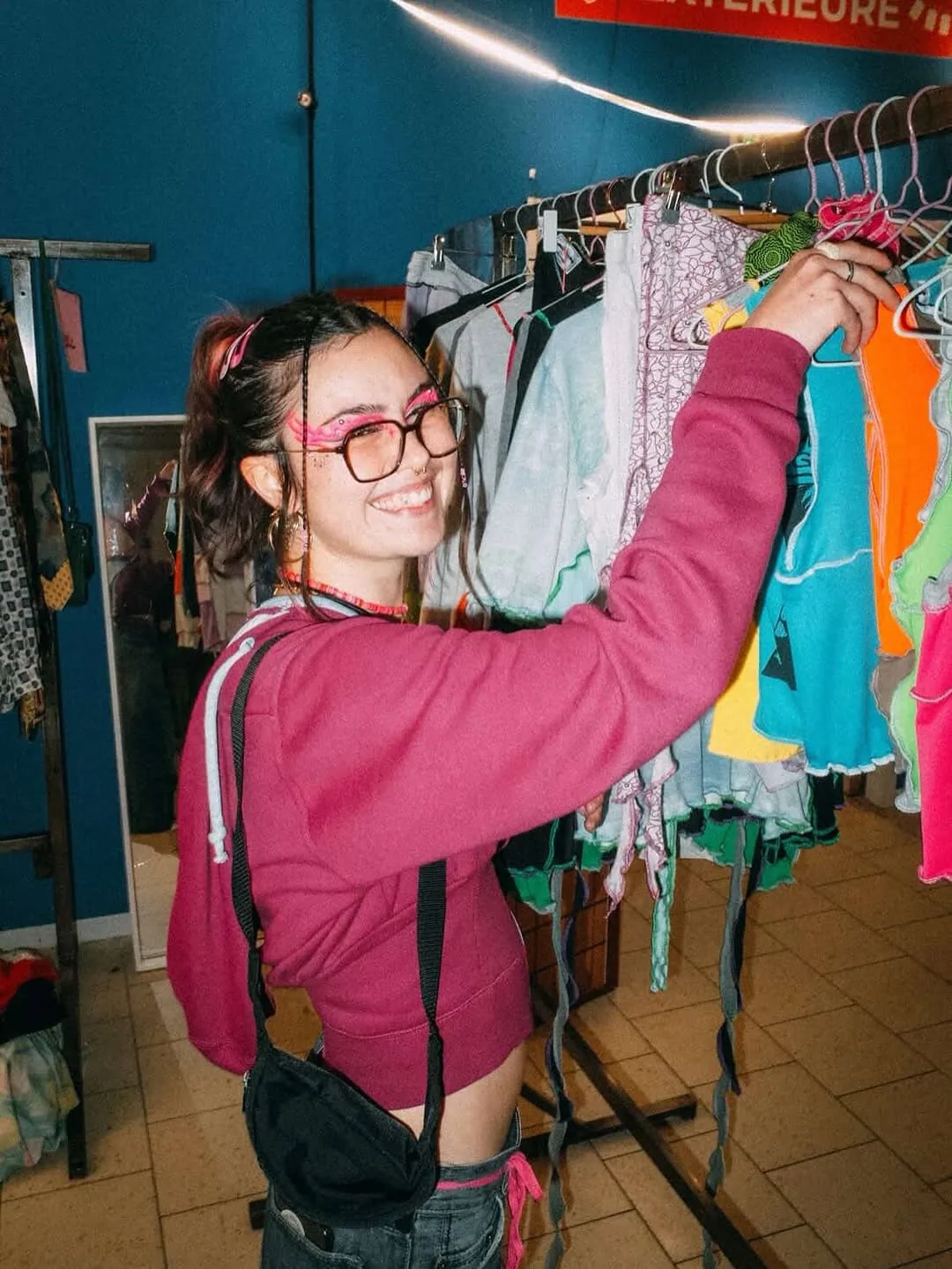 Lilas devant un portant de hauts colorés pendant un pop-up